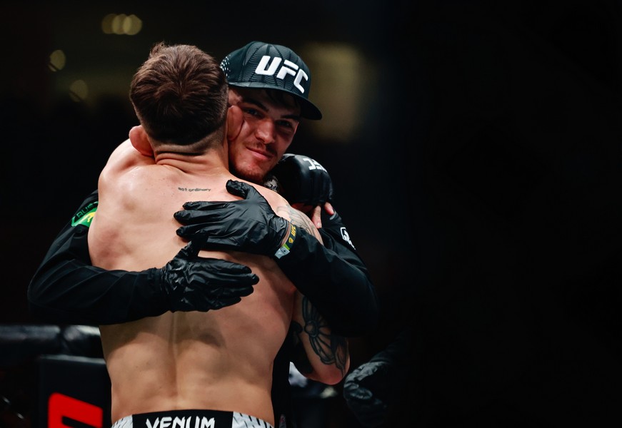 Kaan Ofli being hugged by his team member after his win